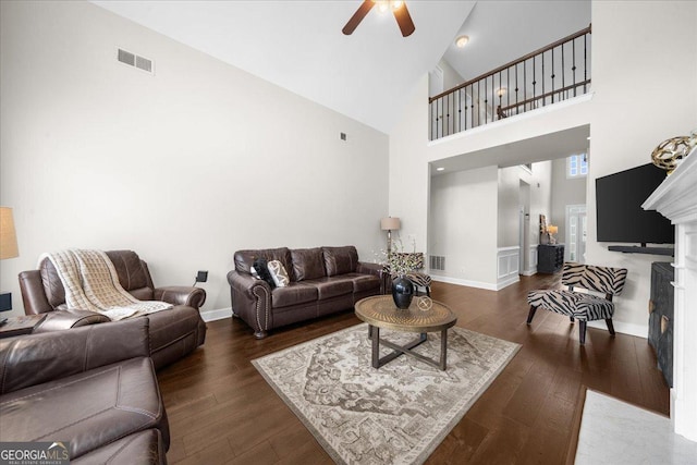 living area featuring dark wood-type flooring, a fireplace with flush hearth, visible vents, and baseboards