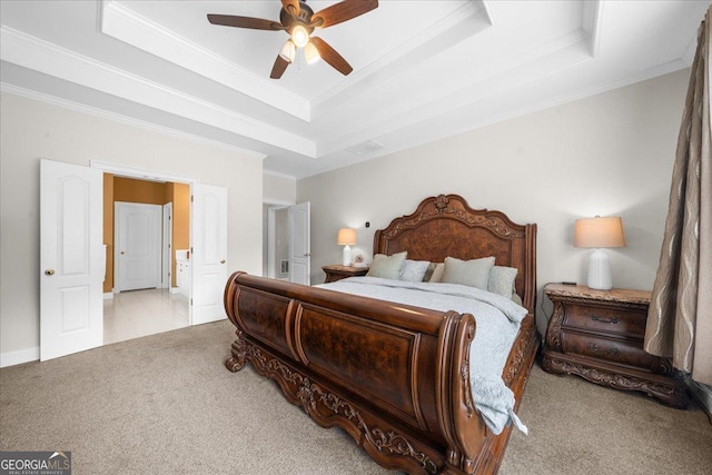 carpeted bedroom with ceiling fan, a tray ceiling, and crown molding