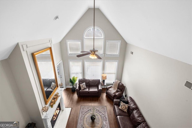 living area featuring high vaulted ceiling, wood finished floors, and a ceiling fan