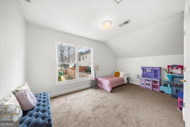 bedroom with lofted ceiling, visible vents, carpet floors, and baseboards