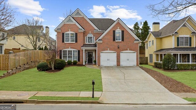 view of front facade featuring brick siding, an attached garage, a front yard, fence, and driveway