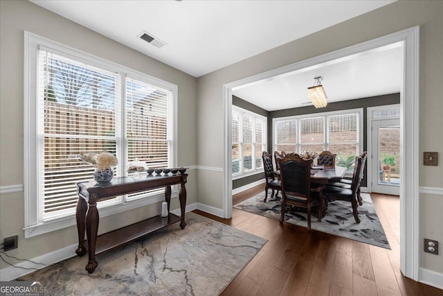 dining area with plenty of natural light, wood-type flooring, visible vents, and baseboards