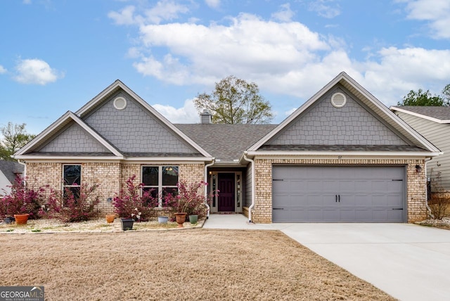 view of front of home featuring brick siding, roof with shingles, a chimney, a garage, and driveway