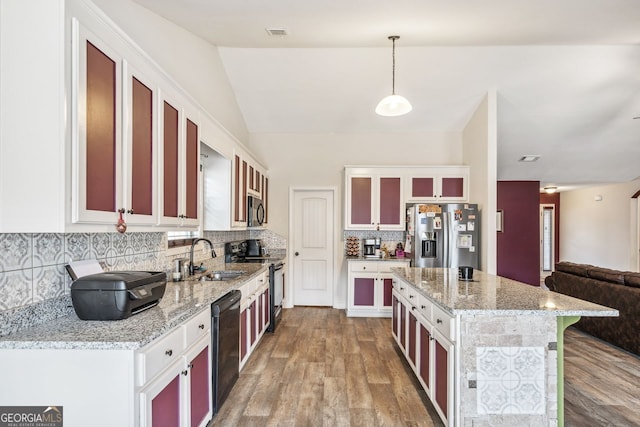 kitchen featuring a sink, a kitchen island, appliances with stainless steel finishes, and wood finished floors