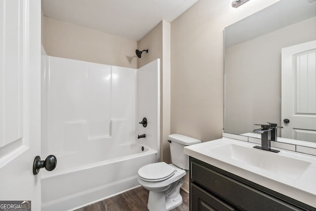 full bath featuring bathing tub / shower combination, toilet, wood finished floors, and vanity