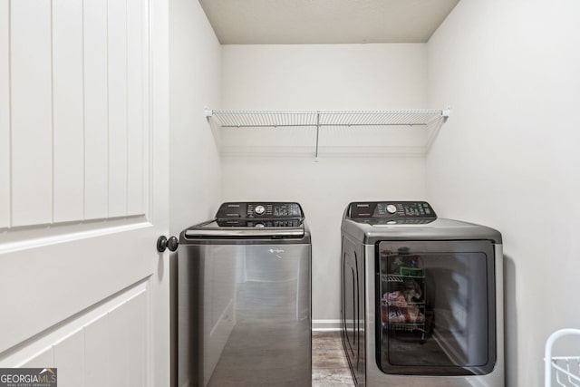 laundry area with washer and clothes dryer, laundry area, and wood finished floors