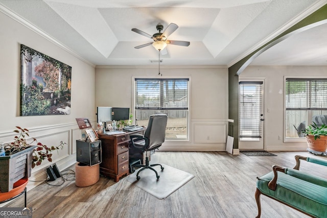 office space featuring visible vents, arched walkways, a raised ceiling, and wood finished floors