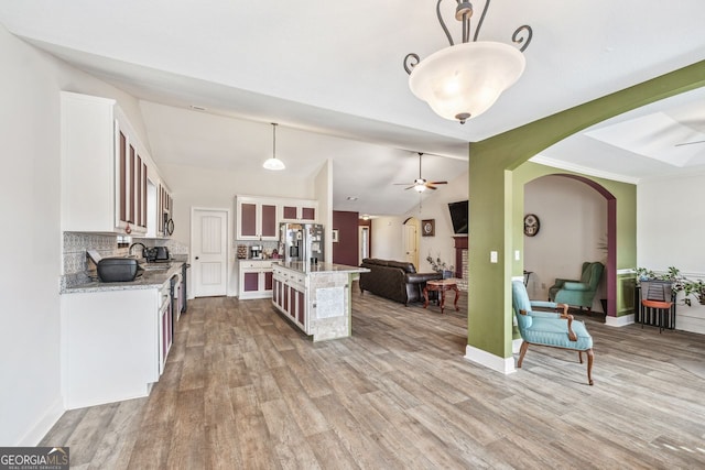 kitchen featuring stainless steel fridge with ice dispenser, open floor plan, lofted ceiling, wood finished floors, and white cabinetry