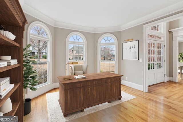 home office with crown molding, light wood-type flooring, and baseboards