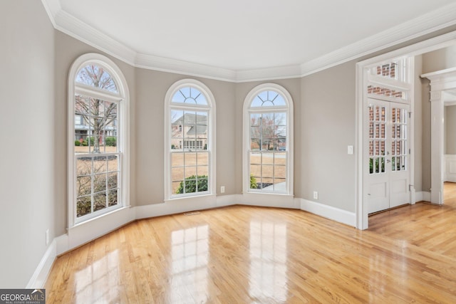 unfurnished dining area featuring a wealth of natural light, baseboards, wood finished floors, and crown molding