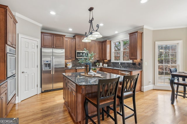 kitchen with tasteful backsplash, stainless steel appliances, a breakfast bar, and ornamental molding