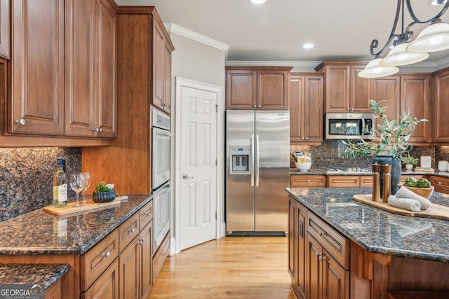 kitchen with brown cabinets, backsplash, appliances with stainless steel finishes, and crown molding