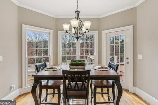 dining area featuring a notable chandelier, baseboards, light wood-type flooring, and ornamental molding