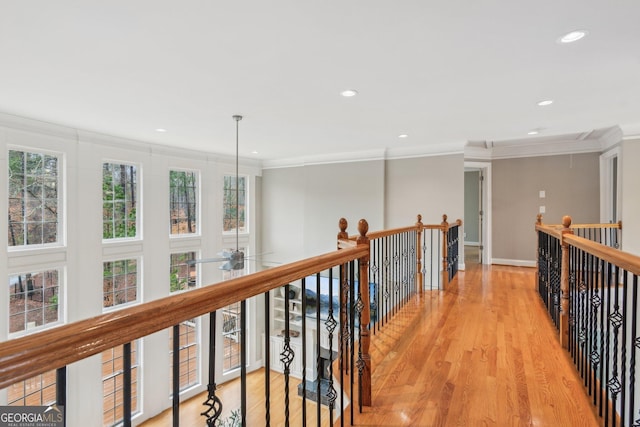 corridor featuring attic access, recessed lighting, light wood-style floors, crown molding, and an upstairs landing