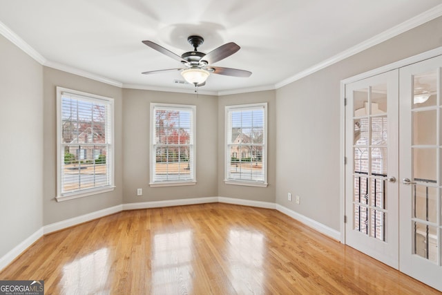 spare room with a healthy amount of sunlight, french doors, light wood-type flooring, and ornamental molding