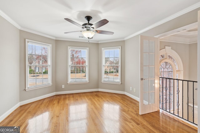 empty room with a healthy amount of sunlight, wood finished floors, and ornamental molding