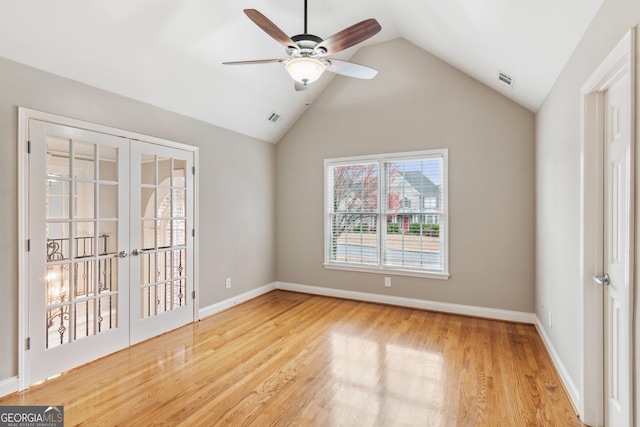 spare room featuring visible vents, baseboards, lofted ceiling, french doors, and wood finished floors