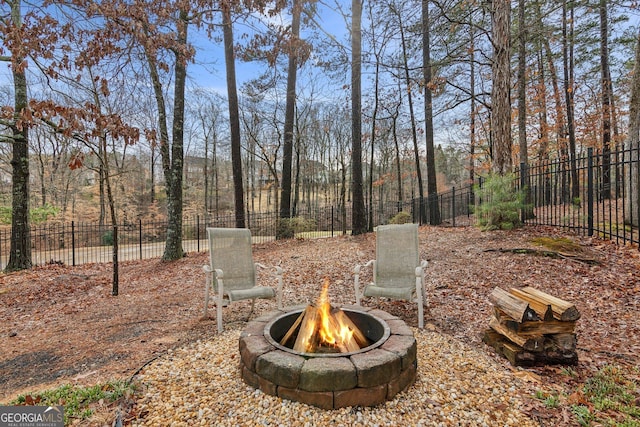 view of yard with an outdoor fire pit and fence