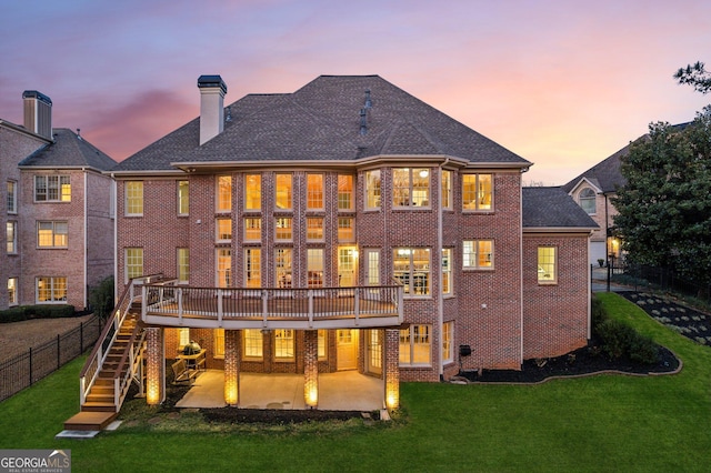 rear view of property with a patio, stairway, a lawn, and brick siding