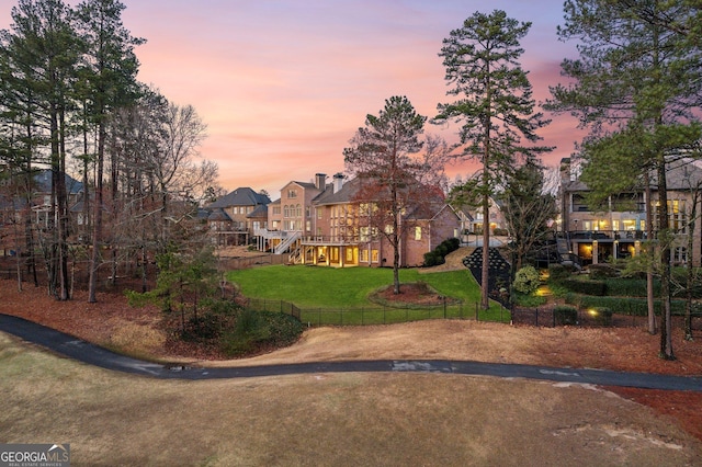 exterior space with a yard, a residential view, playground community, and fence