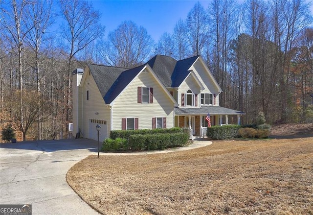 view of front of home with a garage, concrete driveway, and a porch