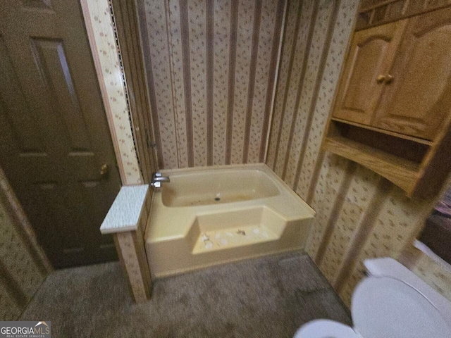 full bath with toilet, wallpapered walls, and a bathing tub