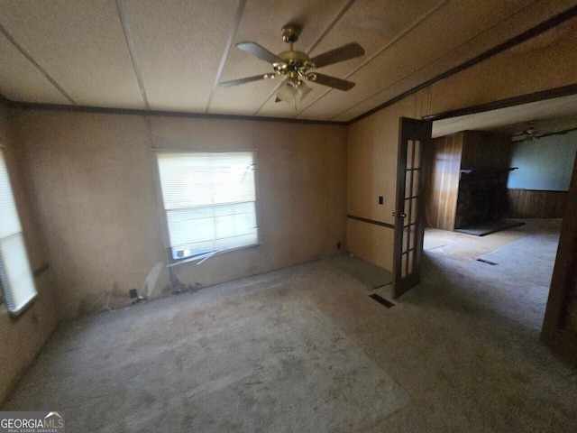 carpeted spare room featuring ceiling fan and visible vents