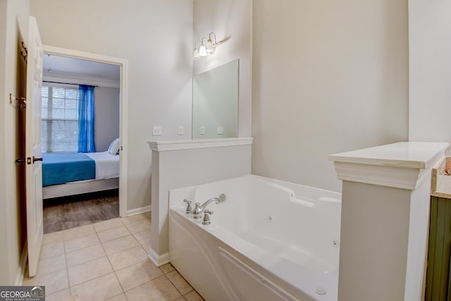 bathroom featuring ensuite bathroom, a whirlpool tub, tile patterned flooring, baseboards, and vanity