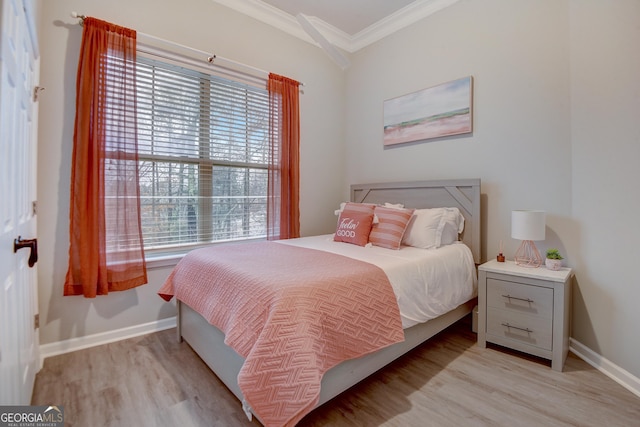 bedroom featuring crown molding, baseboards, and wood finished floors