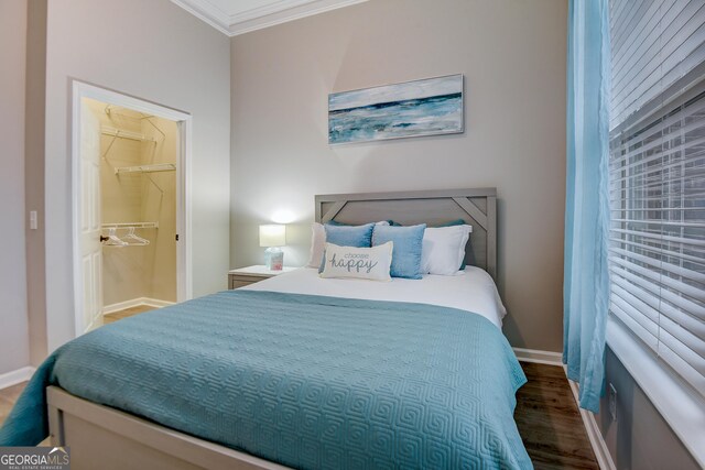 bedroom featuring ornamental molding, baseboards, and wood finished floors