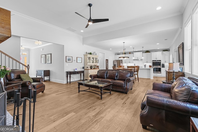 living area featuring crown molding, stairway, recessed lighting, light wood-style flooring, and a ceiling fan