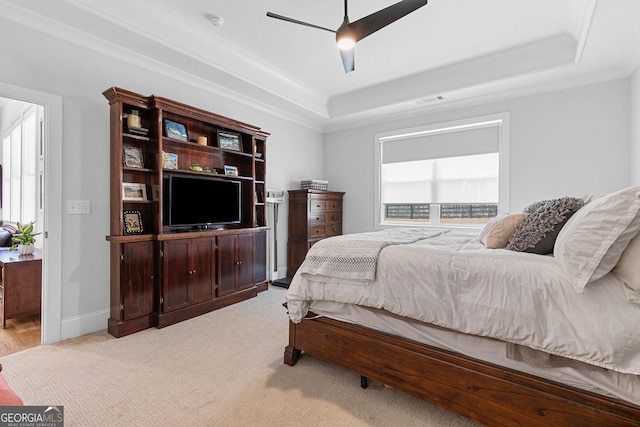 bedroom featuring visible vents, ceiling fan, baseboards, a tray ceiling, and ornamental molding