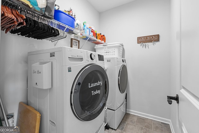 washroom featuring laundry area, washing machine and dryer, and baseboards