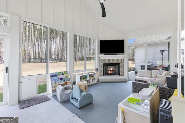 sunroom with a wealth of natural light, a brick fireplace, and lofted ceiling