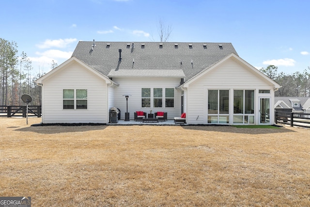 rear view of property featuring fence, a sunroom, a shingled roof, a patio area, and a lawn