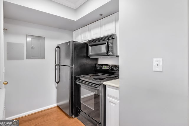 kitchen with black appliances, light wood-style floors, electric panel, and white cabinetry