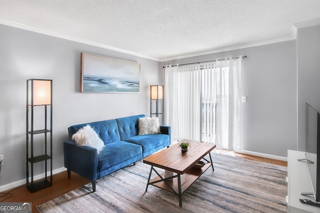 living area with baseboards, a textured ceiling, ornamental molding, and wood finished floors