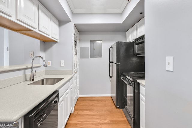 kitchen with light countertops, white cabinets, a sink, electric panel, and black appliances