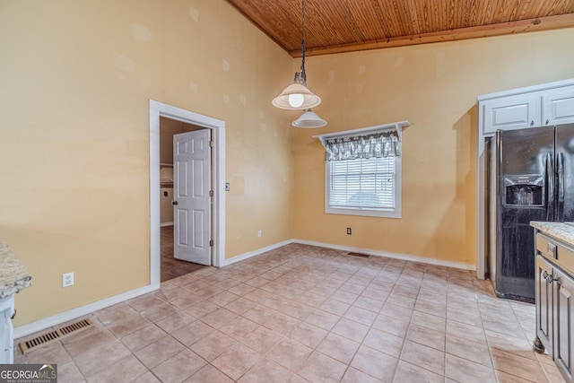 unfurnished dining area with wood ceiling, visible vents, and light tile patterned floors