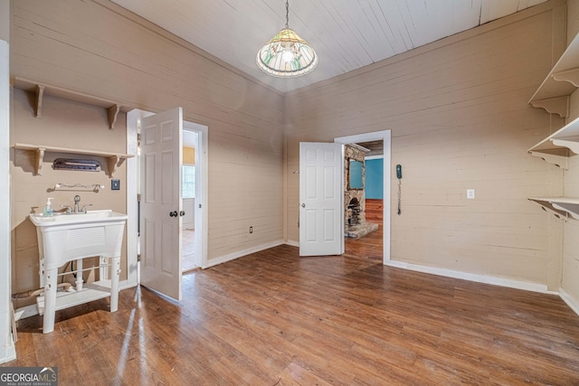 dining space with wooden walls, baseboards, and wood finished floors