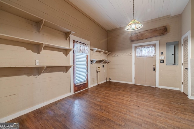 interior space featuring laundry area, plenty of natural light, electric panel, and wood finished floors