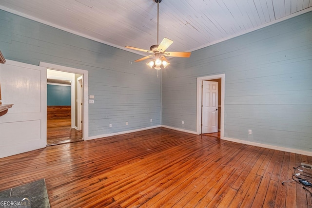 empty room featuring ceiling fan, hardwood / wood-style floors, and baseboards