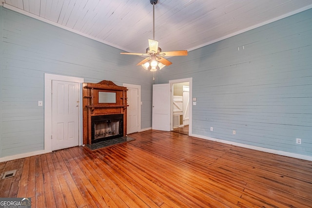 unfurnished living room featuring ceiling fan, a fireplace, wood-type flooring, and visible vents