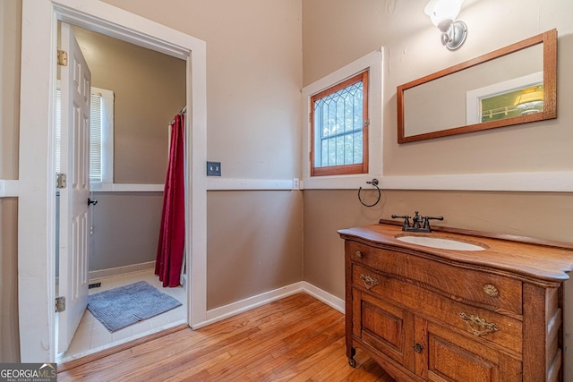 bathroom featuring baseboards, wood finished floors, and vanity