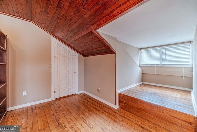 additional living space featuring lofted ceiling, hardwood / wood-style floors, wood ceiling, and baseboards