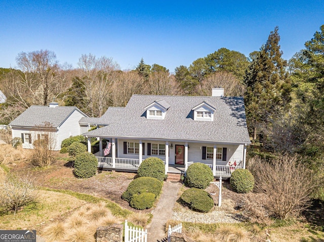 view of front of home with fence, a porch, and roof with shingles