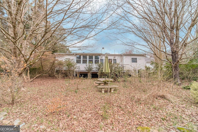 back of house featuring a chimney