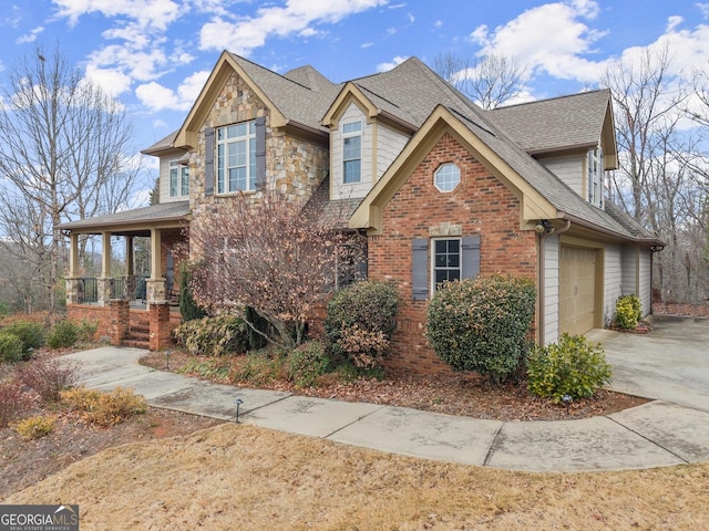 view of front of house with brick siding, roof with shingles, covered porch, a garage, and driveway