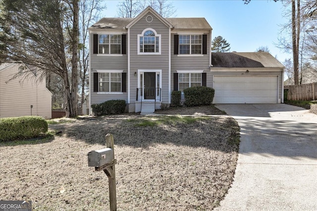 colonial-style house with driveway, an attached garage, and fence