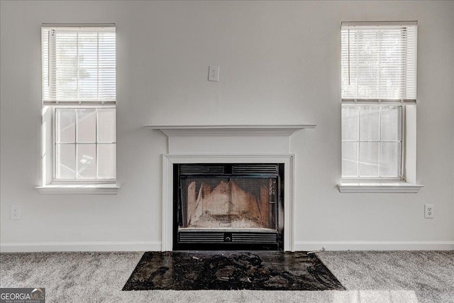 interior details with carpet floors, a fireplace, and baseboards